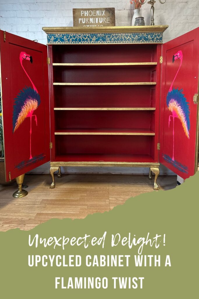 An open, upcycled cabinet from Phoenix Furniture, painted inside with vibrant red and adorned with colorful flamingo illustrations on the doors. The text below reads, "Unexpected Delight! UPCYCLED CABINET WITH A FLAMINGO TWIST.