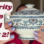 A person holds a vintage Wedgwood dish with intricate blue floral patterns. Text reads "Charity Shop Haul Part 2!" and "Wedgwood late 1800's!!" The person's nails are painted in lavender.